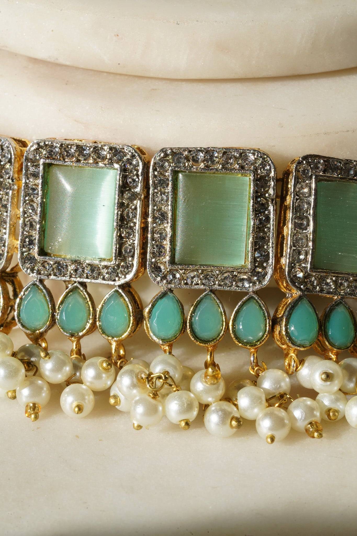 Jahanara Gold Plated Choker Necklace Set - Artisan crafted with cushion cut center stones, zircon rims, teardrop accents, 1.5" earrings, and a charming maang tikka.