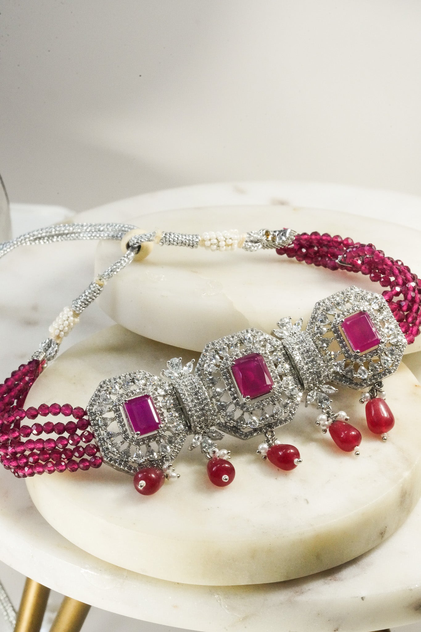 Jhanvi Choker Necklace Set - Silver & Gem Variations featuring cushion-cut AD stones with ruby teardrop accents, includes matching earrings.