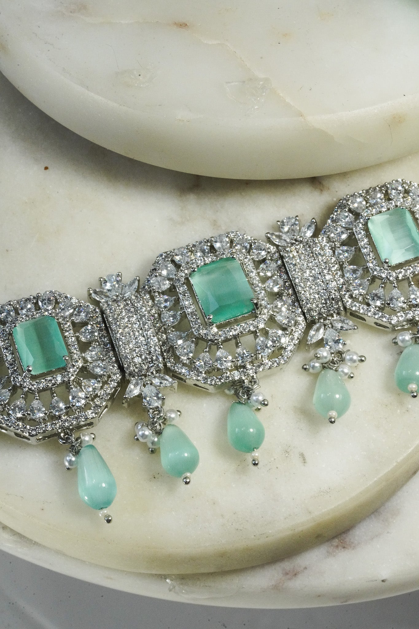 Jhanvi Choker Necklace Set - Silver & Gem Variations featuring cushion-cut AD stones with mint green teardrop accents, includes matching earrings.