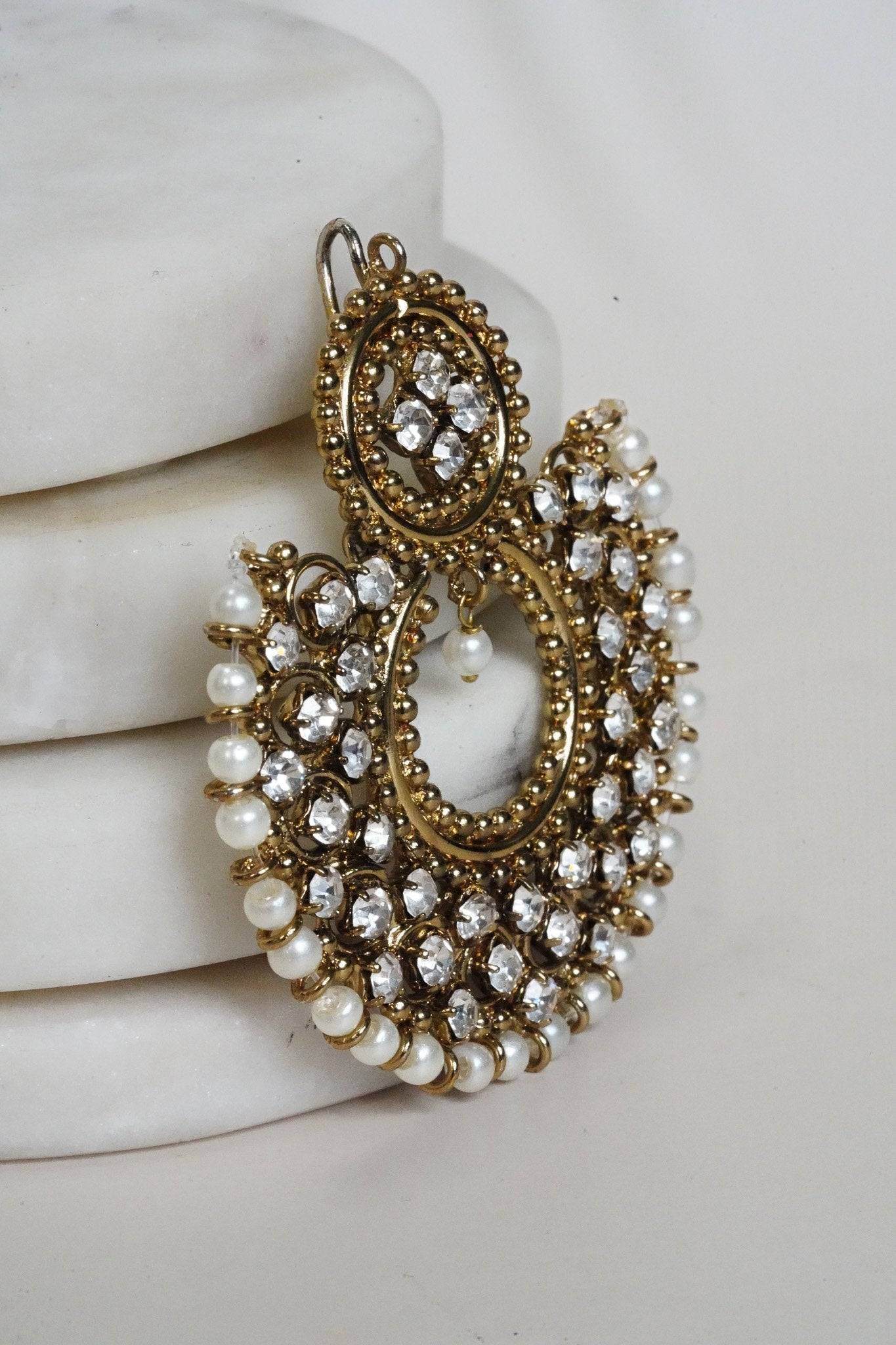 Side view of Laila Chandbali Earring in antique gold, showcasing intricate stonework and pearl detailing on a white surface.