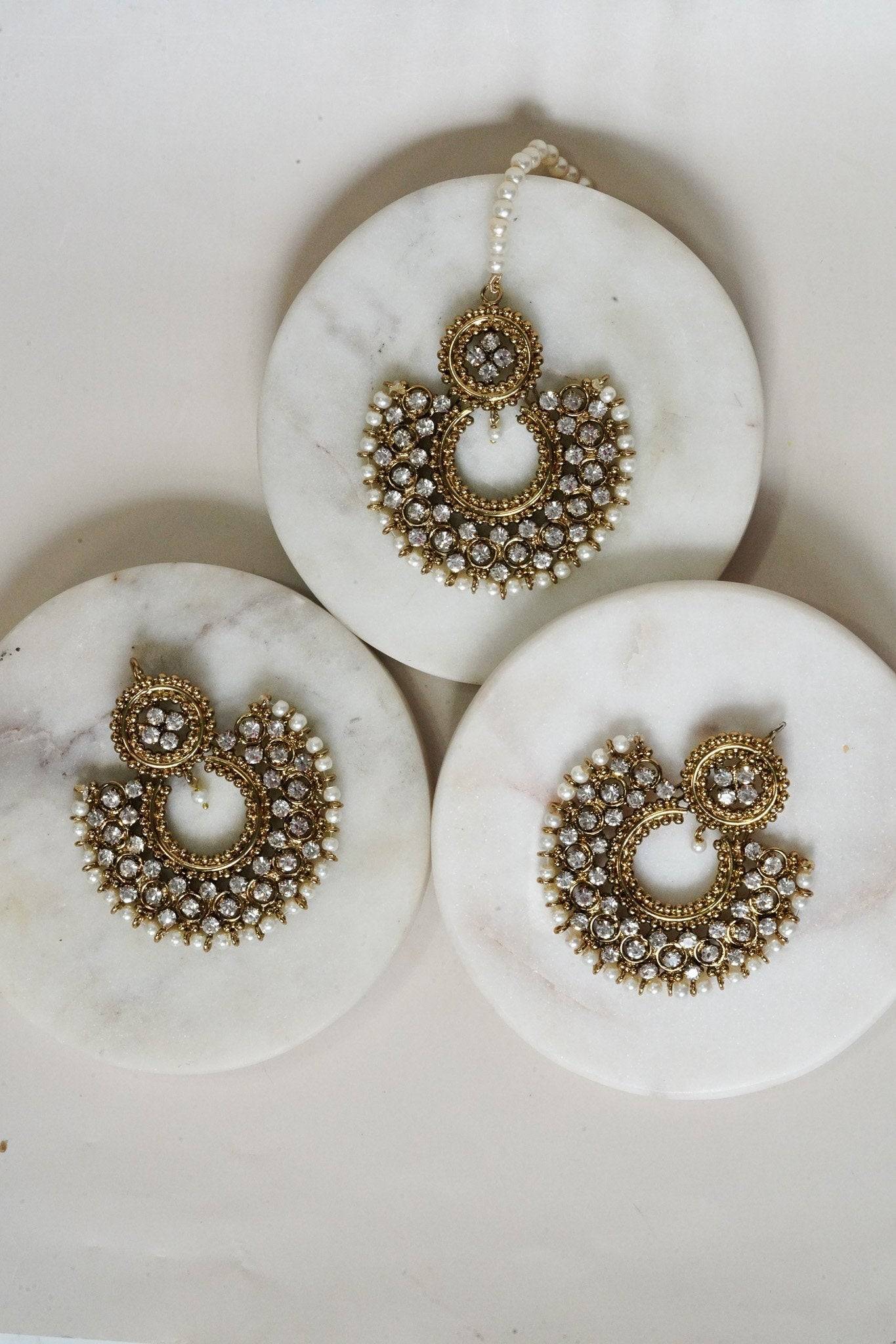 Complete Laila Chandbali Earrings and Maang Tikka Set in antique gold, laid out on white marble for a luxurious presentation.