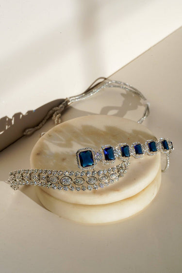 Mahi Asymmetrical Choker Necklace Set - Rhodium-plated with AD stones, available in silver & green, silver & ruby, and silver & sapphire blue, perfect for contemporary elegance.