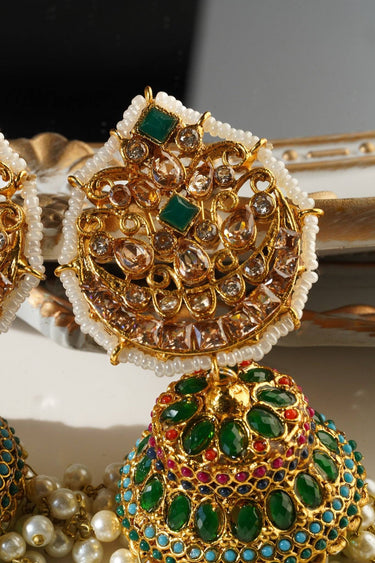 Heritage inspired Mishti Jhumkas with green and red stones, gold finish, and pearl accents, ideal for traditional Indian attire.