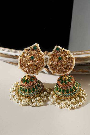 Mishti Statement Jhumkas in green and gold with intricate detailing, pearl fringe, and emerald embellishments for traditional Indian wear.