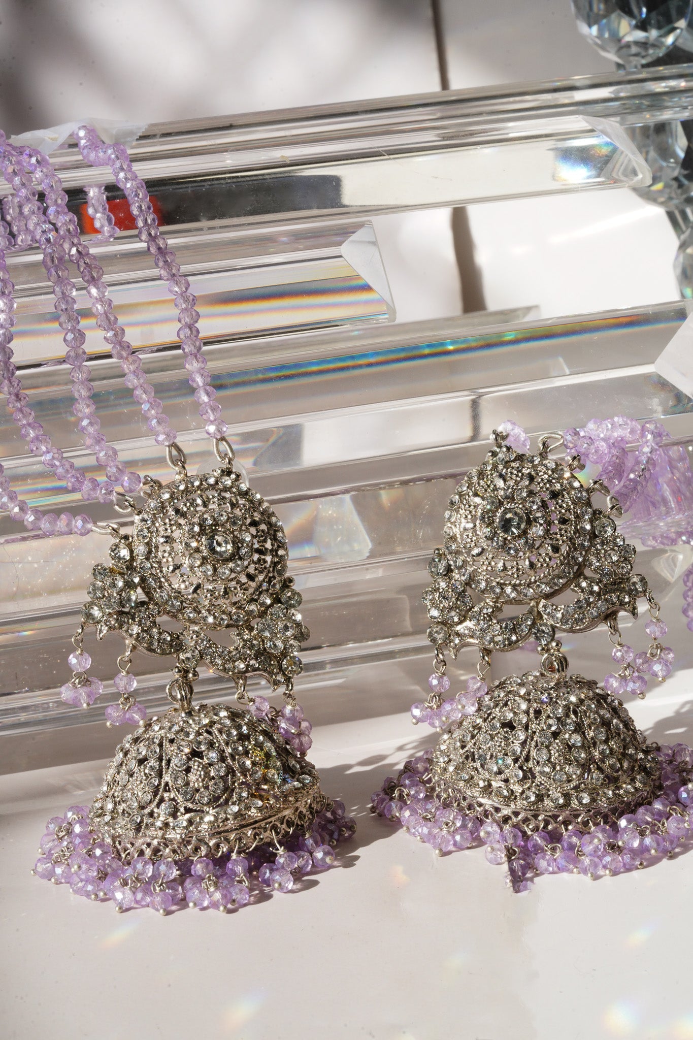 Lavender beaded earrings from Namar Choker Necklace Set with CZ stones, displayed on crystal background.