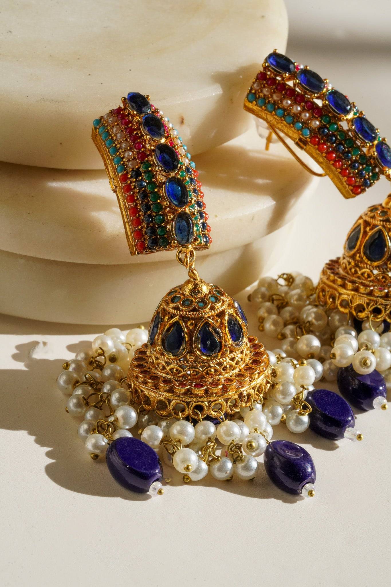 Navdeep Jhumka Earrings - Handcrafted with antique gold plating, available in ruby, blue, or gold, featuring multi-color stones and embellishments.
