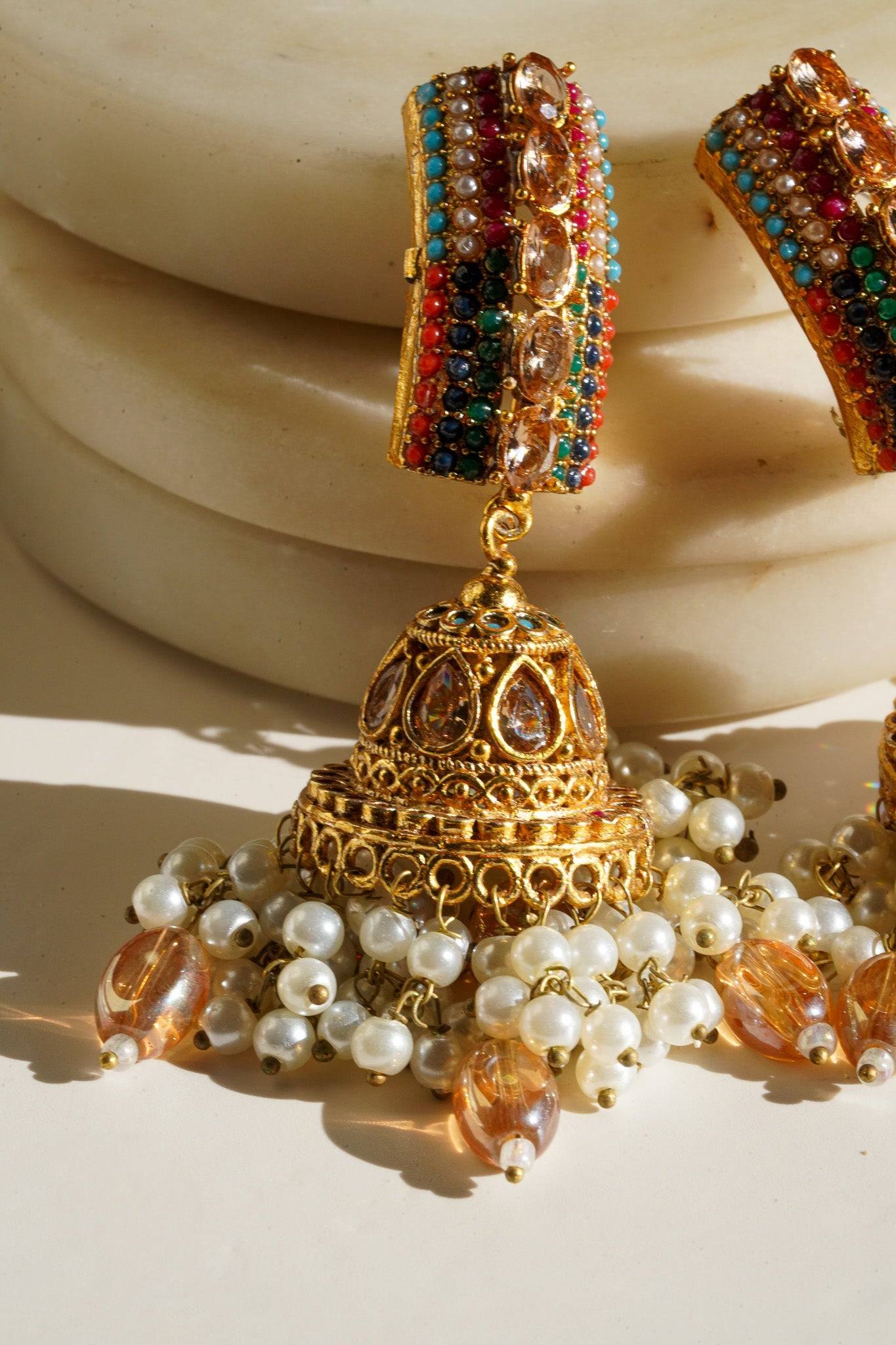 Navdeep Jhumka Earrings - Handcrafted with antique gold plating, available in ruby, blue, or gold, featuring multi-color stones and embellishments.