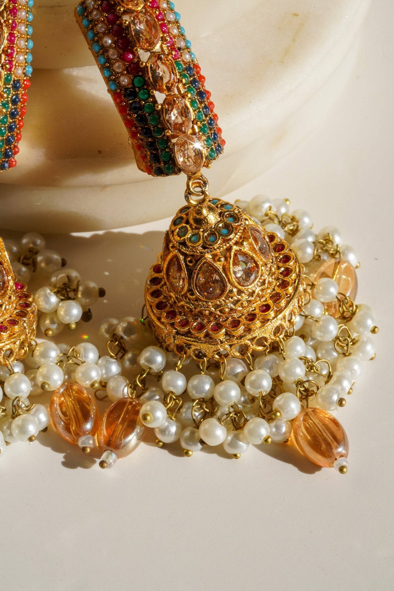 Navdeep Jhumka Earrings - Handcrafted with antique gold plating, available in ruby, blue, or gold, featuring multi-color stones and embellishments.