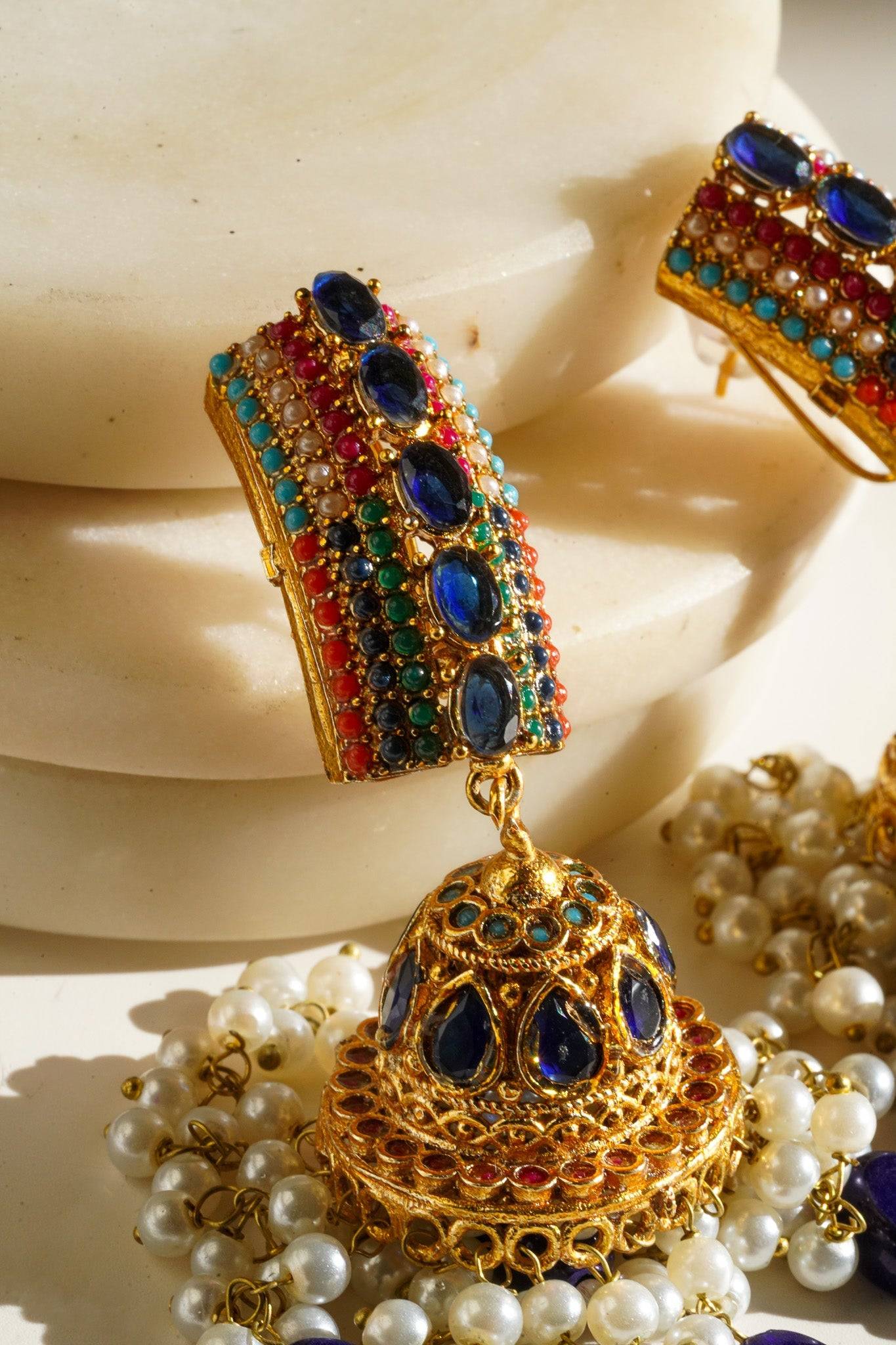 Navdeep Jhumka Earrings - Handcrafted with antique gold plating, available in ruby, blue, or gold, featuring multi-color stones and embellishments.