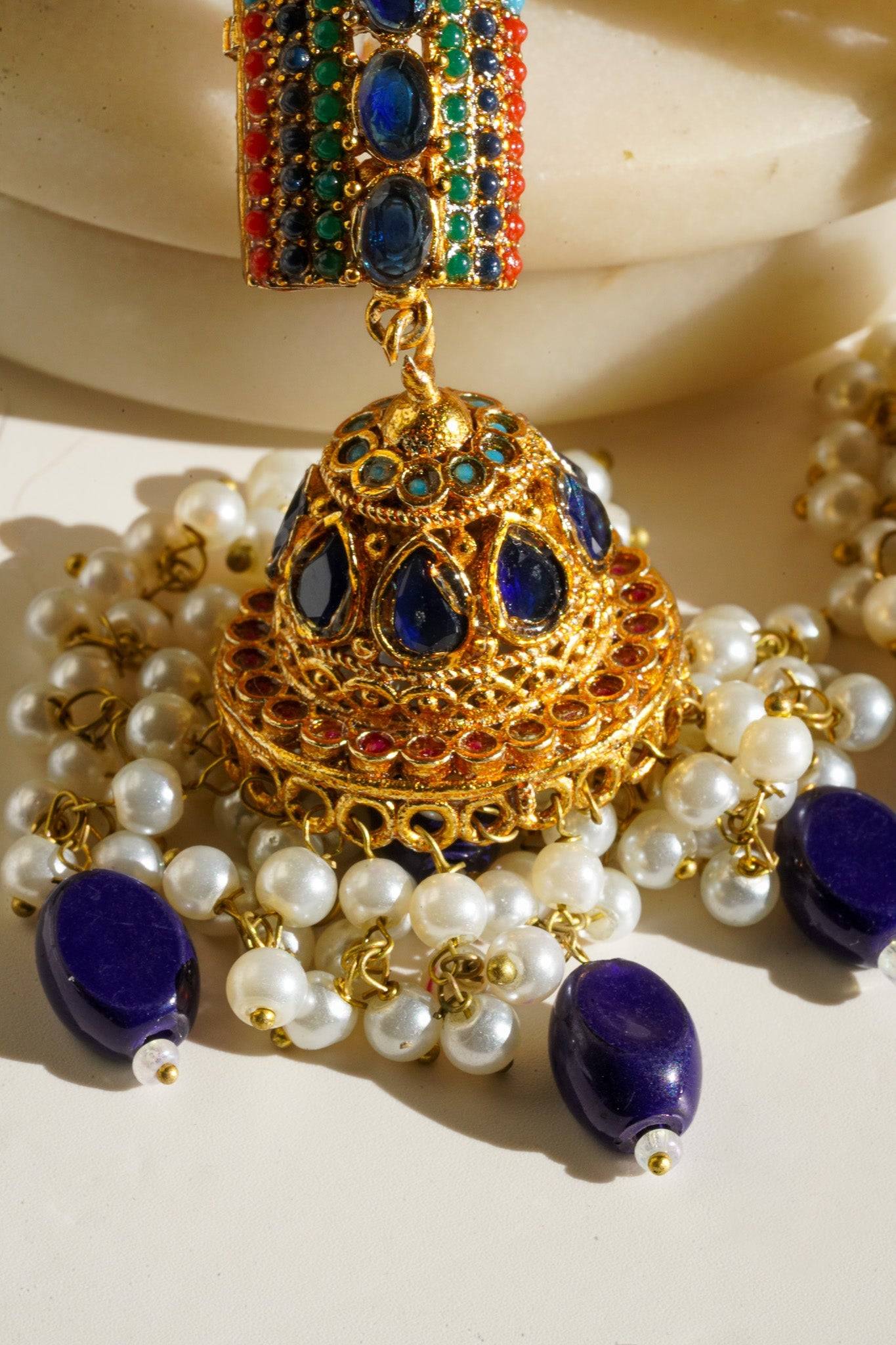 Navdeep Jhumka Earrings - Handcrafted with antique gold plating, available in ruby, blue, or gold, featuring multi-color stones and embellishments.