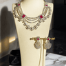 Neha Diamanté Accent Classic Necklace Set - Rhodium-plated with ruby or green accents, floral pattern, curvy layers, and matching 2-inch earrings.