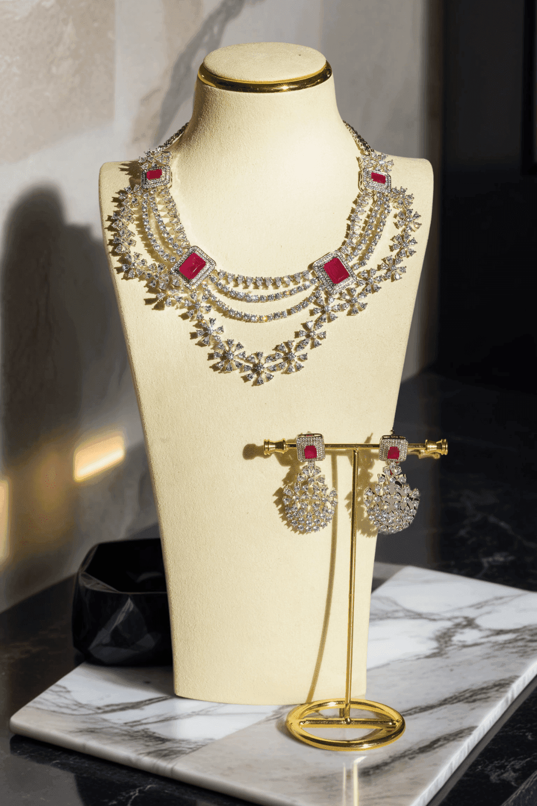 Neha Diamanté Accent Classic Necklace Set - Rhodium-plated with ruby or green accents, floral pattern, curvy layers, and matching 2-inch earrings.