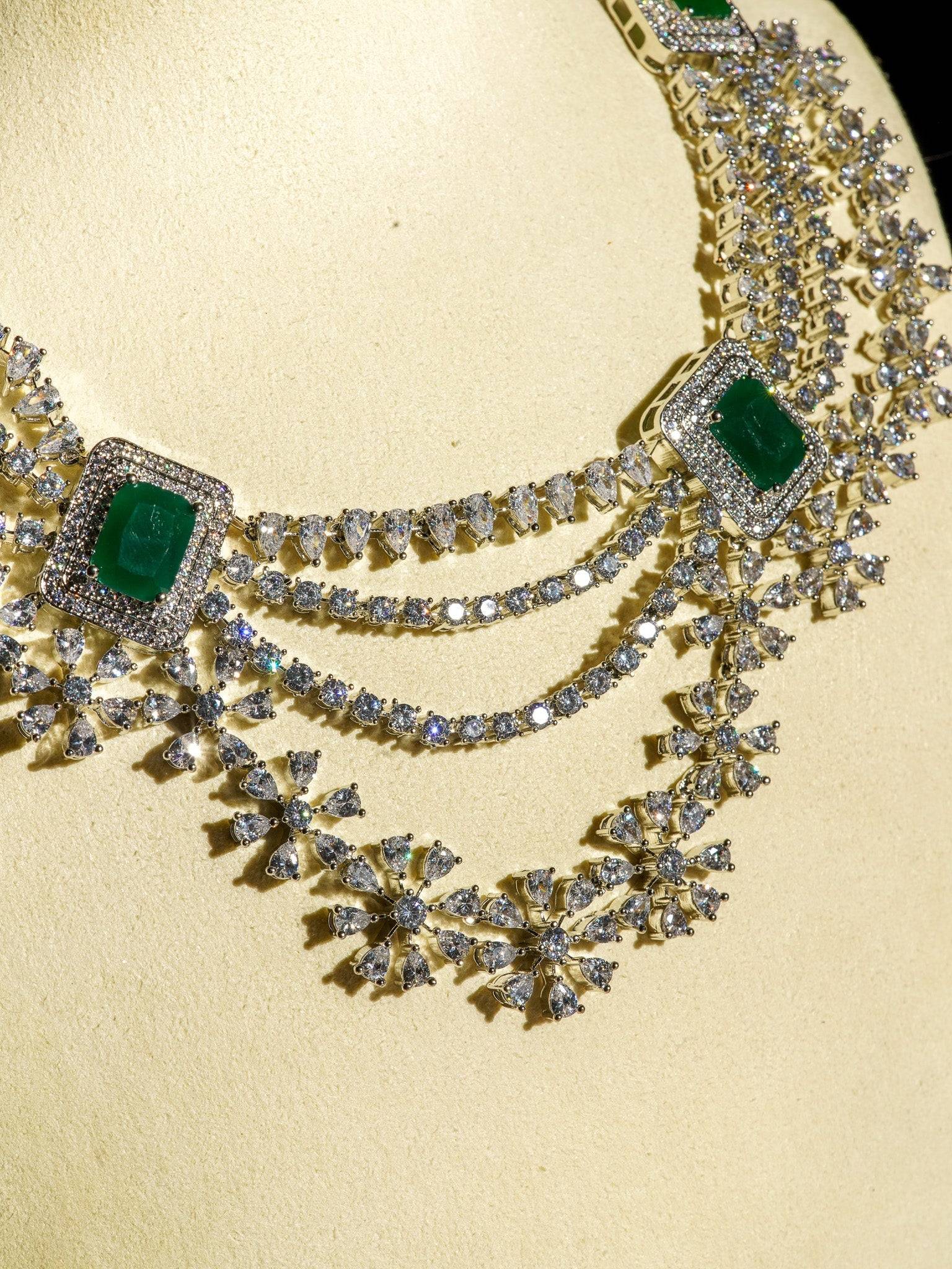 Neha Diamanté Accent Classic Necklace Set - Rhodium-plated with ruby or green accents, floral pattern, curvy layers, and matching 2-inch earrings.