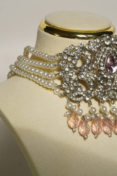 Close-up of Noreen Choker Necklace Set - Elegant Pakistani Bridal Jewels showing pearl strands and pink teardrop stones on display bust.