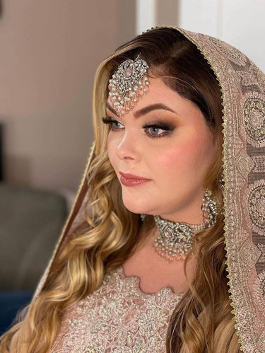 Side view of bride in Noreen Choker Necklace Set - Elegant Pakistani Bridal Jewels, showcasing tikka and choker with pink gemstone accents.