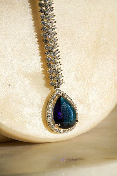 Safi - Rhodium-plated maang tikka with white American Diamonds and a sapphire blue teardrop accent from Inaury