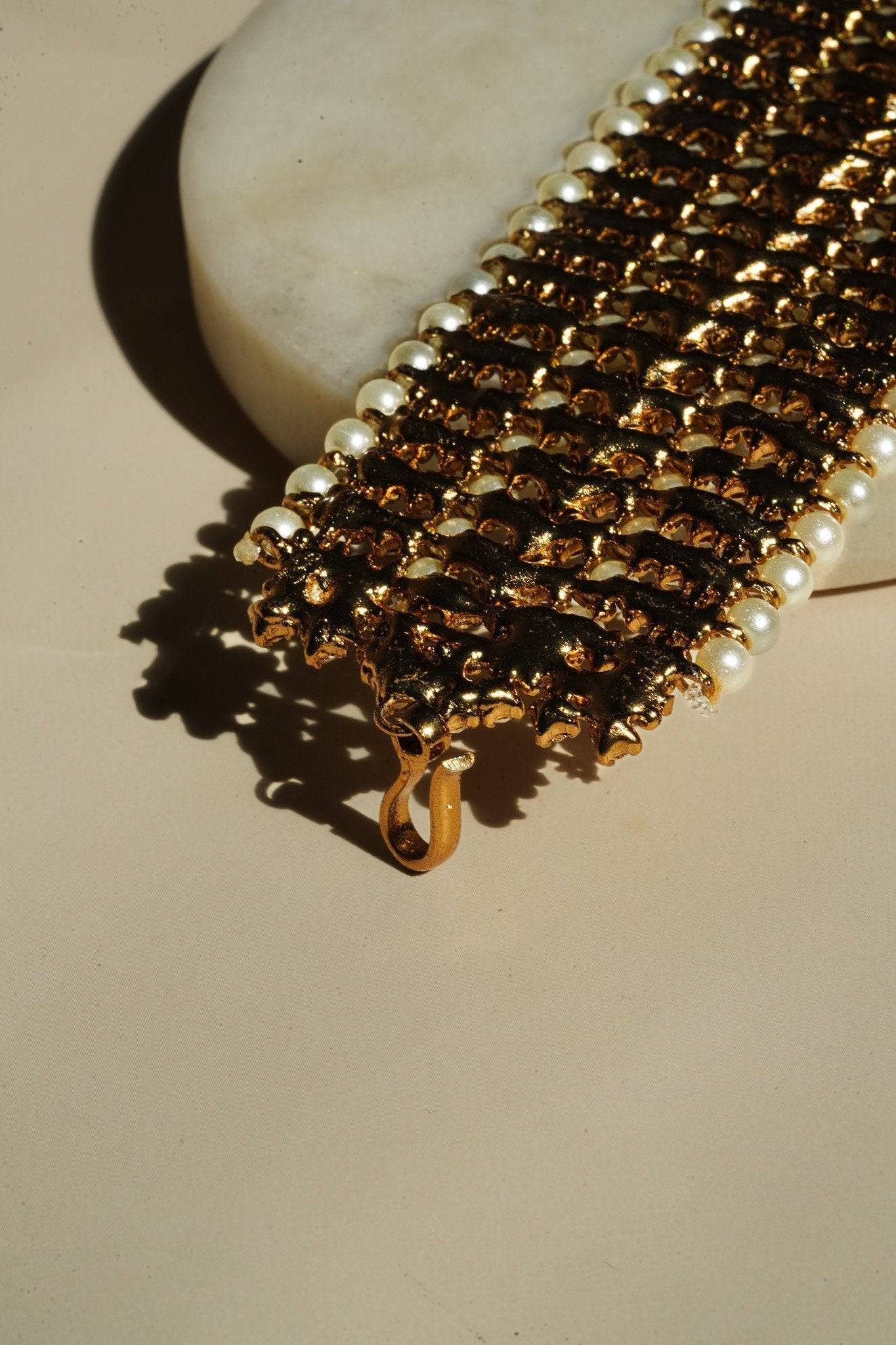 Back clasp detail of Samia Bangles in gold with pearl accents, showing secure hook closure and intricate metalwork.