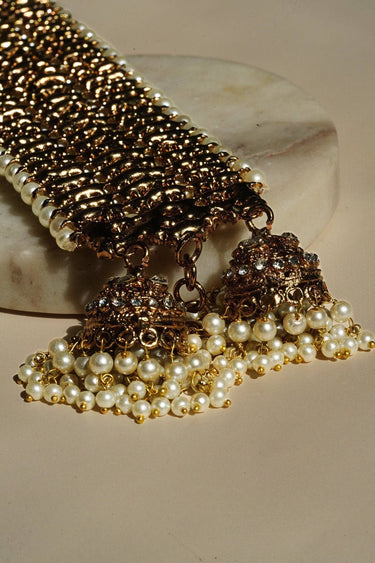 Zoomed-in view of Samia Bangles' jhumkas with pearl drops and gold detailing, highlighting fine craftsmanship and festive appeal.