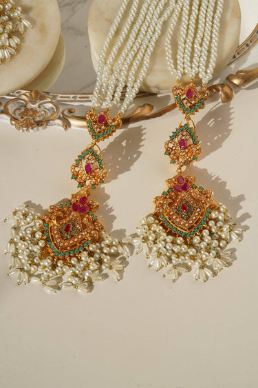 Close-up of Sanjana Earrings & Tikka Set with pink and green stones, pearls, and ornate goldwork for festive and bridal looks.