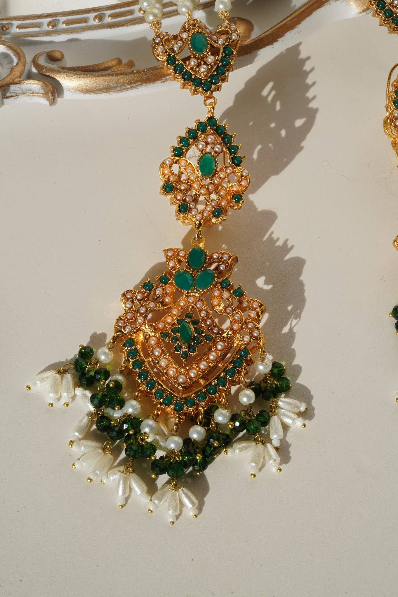 Green and gold earring detail from Sanjana Set with pearl tassels, ideal for traditional South Asian outfits.
