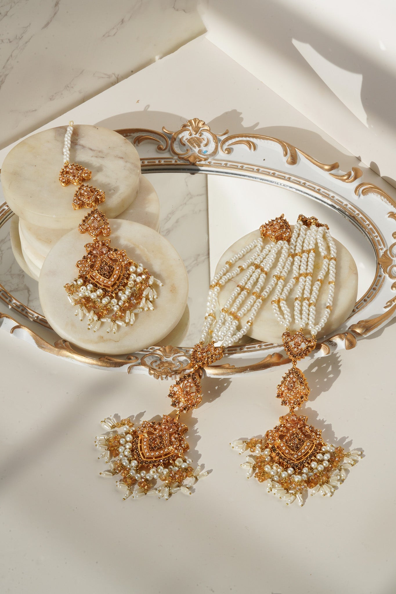 Sanjana Earrings & Tikka Set in gold with white pearls, showcasing regal craftsmanship for weddings and festivals.