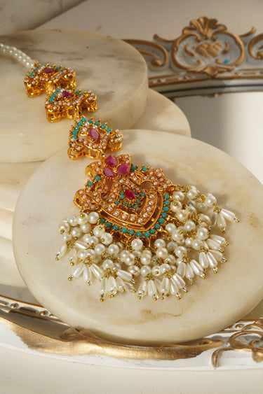 Detailed view of Sanjana Maang Tikka with pink, green, and gold embellishments, finished with pearl tassels for a royal touch.