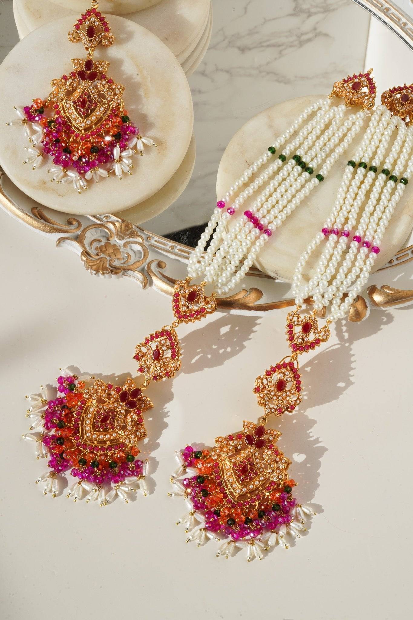 Colorful Sanjana Jewelry Set with Navratan stones and pearl tassels, blending Indian and Pakistani design elements.