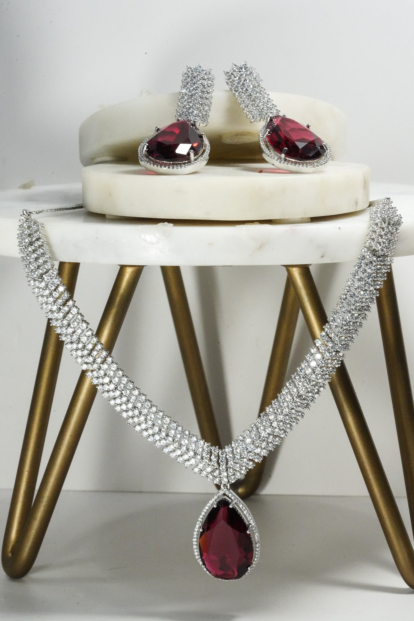 Sharmine Paved Silver Diamanté Accent Necklace Set - Rhodium-plated with Diamanté stones, featuring a large teardrop stone and chandelier earrings, available in multiple color options, perfect for modern South Asian ensembles.
