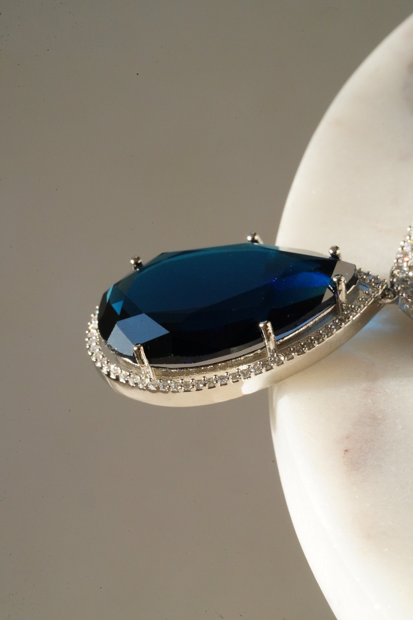 Sharmine Paved Silver Diamanté Accent Necklace Set - Rhodium-plated with Diamanté stones, featuring a large teardrop stone and chandelier earrings, available in multiple color options, perfect for modern South Asian ensembles.