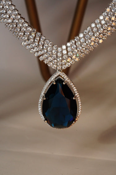 Sharmine Paved Silver Diamanté Accent Necklace Set - Rhodium-plated with Diamanté stones, featuring a large teardrop stone and chandelier earrings, available in multiple color options, perfect for modern South Asian ensembles.