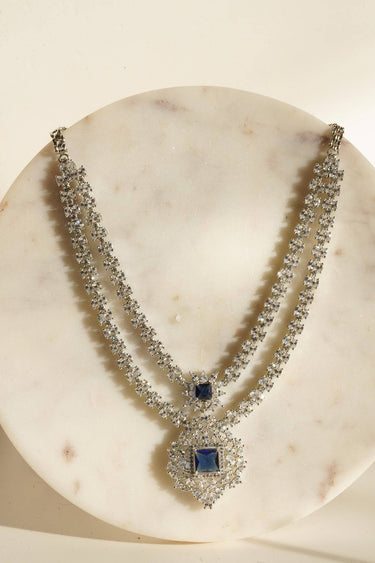 Zeenat Double Layer Diamanté Accent Necklace Set - Rhodium-plated silver finish with intricate detail-cut stones, available in four colors: sapphire blue, emerald green, white, and ruby. Includes matching statement earrings.