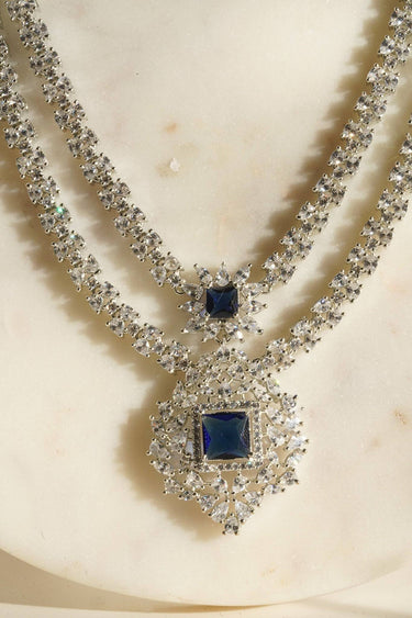 Zeenat Double Layer Diamanté Accent Necklace Set - Rhodium-plated silver finish with intricate detail-cut stones, available in four colors: sapphire blue, emerald green, white, and ruby. Includes matching statement earrings.
